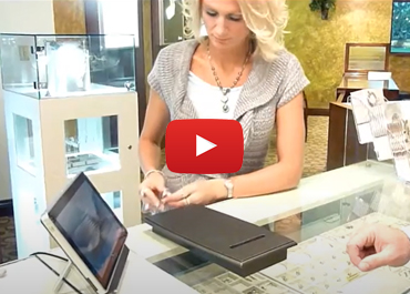 A jewelry store employee scanning a gold ring into inventory using a point of sale rfid scanner